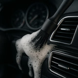 CarVibeX Detailing Pinsel im Einsatz – Reinigung von Lüftungsschlitzen mit Schaum, perfekt für Auto-Innenraum